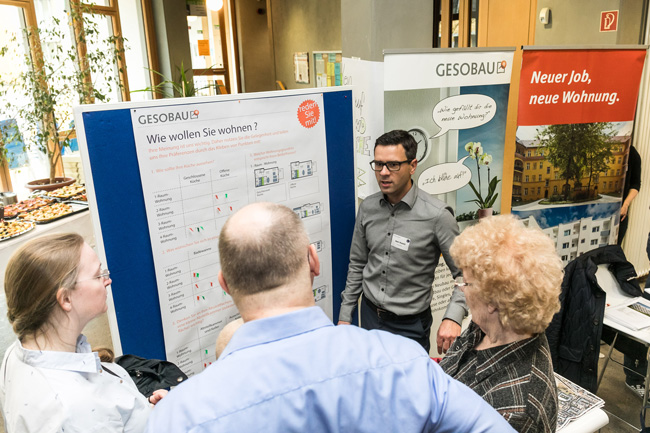 Besucher im Gespräch mit einem Mitarbeiter der GESOBAU