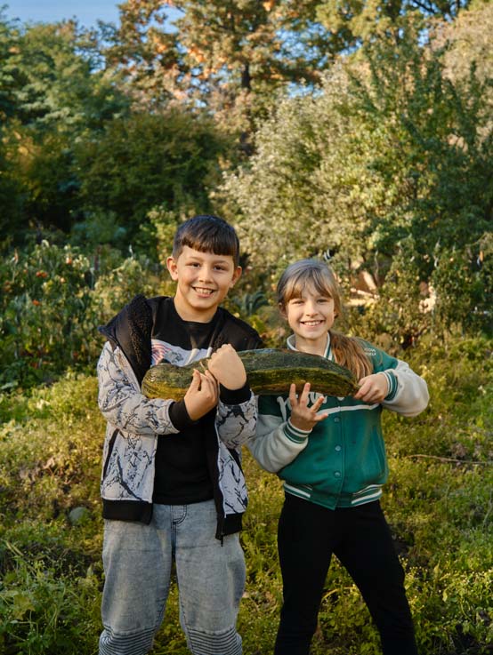 Can und Amelia freuen sich über ihre große Zucchini