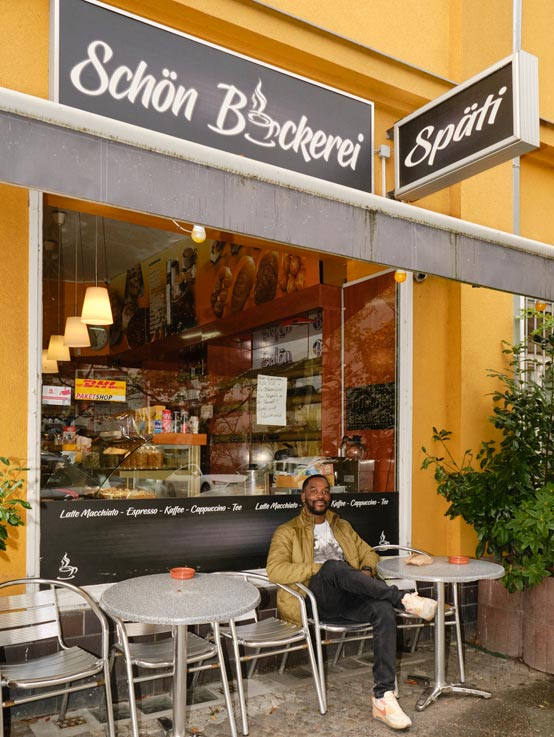 Meist nimmt Vinsley sein Frühstück mit nach Hause, heute setzt er sich aber vor den Laden und beobachtet das bunte Treiben im Kiez 