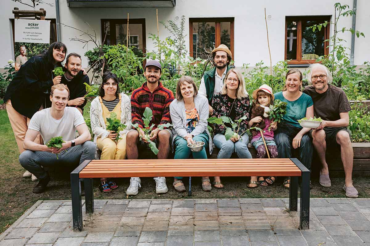 Ernte aus zwei Hochbeeten: Pankower Mieter*innen mit frisch gepflücktem Kohlrabi, Salat und Kräutern