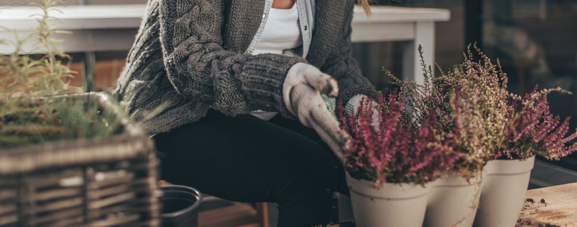 Frau macht Balkon winterfest