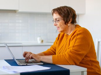 Frau sitzt am Laptop