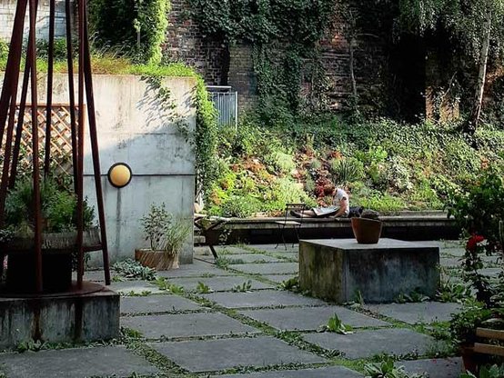 Idyllische Gartenansicht der Bibliothek Luisenbad mit lesenden Menschen