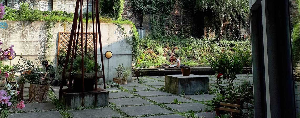 Idyllische Gartenansicht der Bibliothek Luisenbad mit lesenden Menschen