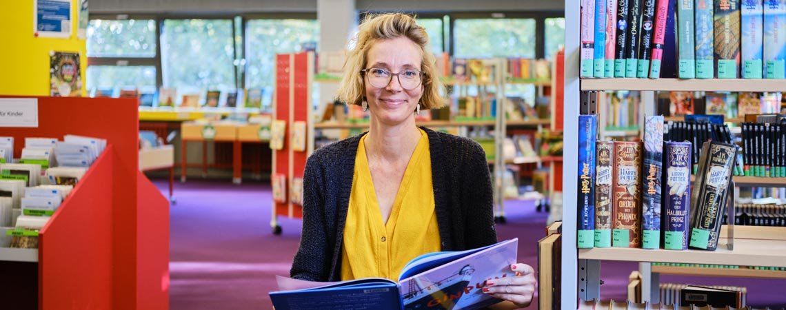 Doreen Lenz inmitten des großen Angebots der Stadtteilbibliothek im Märkischen Viertel