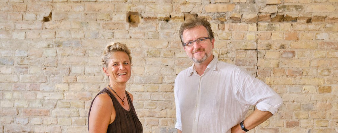 Frau und Mann vor Steinmauer