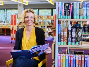 Doreen Lenz inmitten des großen Angebots der Stadtteilbibliothek im Märkischen Viertel