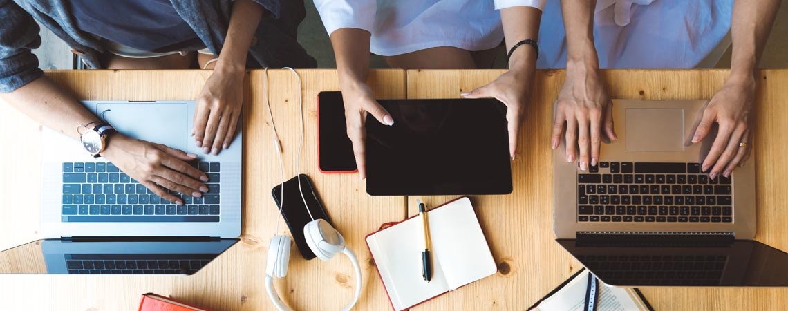 mehrere Personen mit Laptops und Tablets